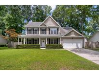 Charming two-story home featuring a covered porch, well-maintained lawn, and attached garage at 8328 Berringer Bluff, North Charleston, SC 29418