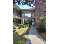 Charming brick apartment building exterior with landscaped courtyard and walkway at 867 Colony Dr # F 118, Charleston, SC 29407