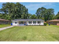 Charming single-story home featuring a neatly manicured lawn and white brick exterior with dark shutters at 8767 Auburn Dr, North Charleston, SC 29406