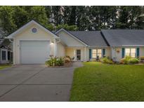 Charming single-story home with attached garage, well-manicured lawn, and welcoming front porch at 9091 Delancey Cir, North Charleston, SC 29406