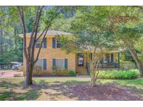 Charming two-story brick home featuring a welcoming front porch and lush landscaping at 105 Greendale Ct, Summerville, SC 29485