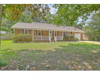 Charming brick home featuring a well-maintained lawn and inviting front porch at 110 Clubhouse Rd, Summerville, SC 29483