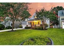 Charming home with a well-manicured lawn, mature trees, and inviting front porch at 114 Marshside Dr, Summerville, SC 29485