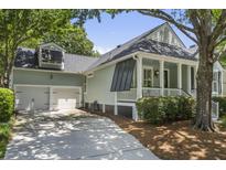 Charming single-story home featuring a well-manicured yard and an attached two-car garage at 116 Cartright St, Daniel Island, SC 29492