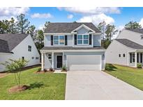 Charming two-story home with a two-car garage and well-manicured lawn at 117 Palfrey Dr, Ridgeville, SC 29472