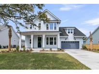 Charming two-story home with a covered front porch and a well-manicured lawn at 1183 Reserve Ln, Awendaw, SC 29429