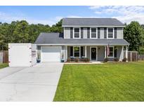 Charming two-story home featuring a well-manicured lawn and an inviting covered front porch at 1514 Stanwick Dr, Johns Island, SC 29455