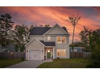 Charming two-story home with a well-manicured lawn and attached one car garage, complete with a lovely walkway at 1989 Nitsa St, Johns Island, SC 29455