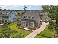 Beautifully landscaped two-story home with a welcoming front porch and well-maintained lawn at 2879 River Vista Way, Mount Pleasant, SC 29466