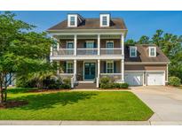 Charming two-story home with a welcoming front porch and manicured lawn on a sunny day at 2997 Sturbridge Rd, Mount Pleasant, SC 29466