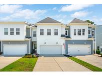 Charming townhomes feature white and gray exteriors, attached garages, and a concrete driveway at 3082 Emma Ln, Mount Pleasant, SC 29466