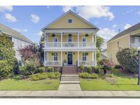 Charming two-story home with double front porches, white railings, manicured lawn, and beautiful landscaping at 312 Germander Ave, Summerville, SC 29483