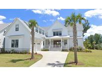 Inviting two-story home with a manicured lawn, attached garage, and a welcoming front porch at 3807 Sawyers Island Dr, Mount Pleasant, SC 29466