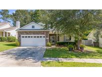 Charming home featuring a stone facade, manicured lawn, and a two-car garage at 404 Norwood Ct, Moncks Corner, SC 29461