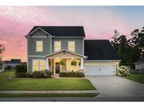 Charming two-story home with a well-manicured lawn, inviting front porch, and attached two-car garage at 404 Topcrest Ln, Moncks Corner, SC 29461