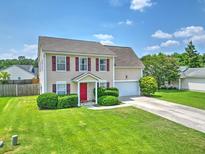 Charming two-story home with a well-manicured lawn, red front door, and attached garage at 412 Beverly Dr, Summerville, SC 29485