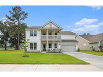 Charming two-story home with a welcoming double porch and well-manicured lawn on a sunny day at 7045 Stonecrop Ln, Johns Island, SC 29455