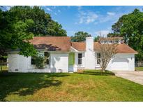 Charming brick home featuring a well-maintained lawn and verdant landscaping at 747 Brant Rd, Charleston, SC 29414
