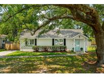 Charming single story home featuring a freshly painted exterior, mature trees, and a well manicured lawn at 8 Tovey Rd, Charleston, SC 29407