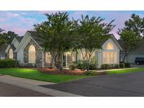 Charming single-story home featuring stone accents, manicured lawn, and mature trees at 8800 Dorchester Rd # 2004, North Charleston, SC 29420