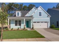 Charming, light blue single-Gathering home with a well-maintained lawn and a bright turquoise front door at 1009 Field Sparrow Dr # Cc3-2-6, Ravenel, SC 29470