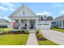 Charming light blue two-story home featuring a welcoming front porch with an American flag at 105 Philips Park St, Summerville, SC 29486