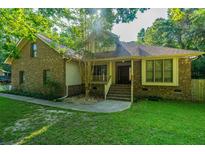 Charming brick and siding home featuring a well-manicured lawn and mature trees at 107 Joes Ln, Summerville, SC 29486