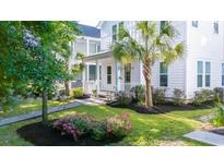 Charming two-story home with lush landscaping, vibrant flowers, and a welcoming front porch at 120 E Respite Ln, Summerville, SC 29483
