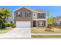Charming two-story brick home featuring a two-car garage and a well-manicured front yard at 1302 Paint Horse Ct, Mount Pleasant, SC 29429