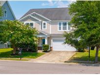 Charming two-story home with a well-maintained lawn, mature trees, and attached two-car garage at 135 Gaslight Blvd, Summerville, SC 29483