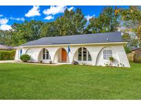Unique home featuring arched windows, a well-manicured lawn, and fresh landscaping elements at 204 Foxborough Rd, Goose Creek, SC 29445