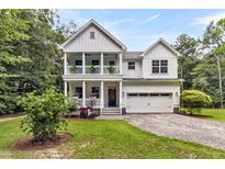 Charming two-story white home featuring a double porch, attached garage, and a well-maintained lawn at 2226 Arthur Rose Ln, Johns Island, SC 29455
