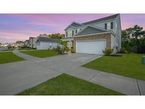 Charming two-story home featuring a two-car garage, brick accents, and a well-manicured lawn in a suburban neighborhood at 225 N Light Way, Summerville, SC 29486