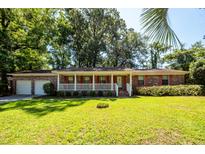 Charming brick home with a white picket fence and a well-manicured green lawn at 2320 Wofford Rd, Charleston, SC 29414