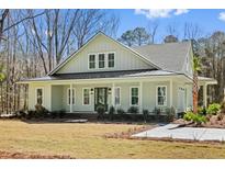 Charming exterior view of a single-story home with a metal roof, inviting front porch, and meticulously landscaped front yard at 2725 Starfish Dr, Johns Island, SC 29455