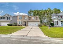 Charming two-story home with a well-maintained lawn and a two car garage, perfect for a growing Gathering at 314 Sanctuary Park Dr, Summerville, SC 29486
