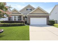 Charming brick home with a well-manicured lawn, a two car garage, and manicured shrubbery at 316 Knawl Rd, Moncks Corner, SC 29461