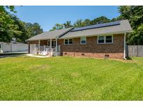 Charming brick home featuring solar panels, a well-maintained lawn, and a welcoming garage at 327 Mcclain St, Charleston, SC 29407