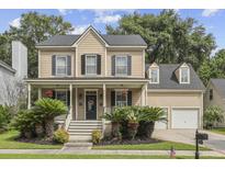 Charming two-story home featuring a welcoming front porch with beautiful landscaping and a two car garage at 3525 E Higgins Dr, Mount Pleasant, SC 29466