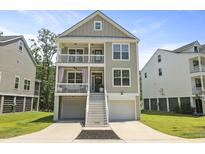 Charming two-story coastal home featuring double balconies, stairs to the entry and well-manicured lawn and landscaping at 3705 Sandy Gate Ln, Mount Pleasant, SC 29466
