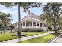 Stunning two-story home with a charming wrap-around porch and an American flag displayed at 401 Ralston Creek St, Charleston, SC 29492