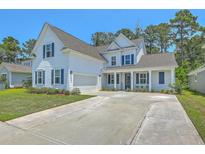 Charming two-story home featuring a spacious driveway, white siding, and delightful blue shutters and front door at 420 Oak View Way, Summerville, SC 29483