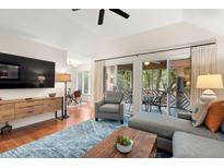 Bright living room with vaulted ceilings, hardwood floors, and access to an outdoor patio at 5558 Green Dolphin Way, Kiawah Island, SC 29455