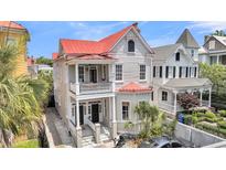 Charming two-story home with a red roof, double porches, and lush greenery at 68 Vanderhorst St # A, Charleston, SC 29403