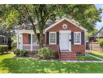 Charming brick home features a well-maintained lawn and a cozy, covered front porch at 727 Savannah Hwy, Charleston, SC 29407