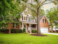 Charming two-story home featuring a brick facade, white trim, and a well-manicured lawn with mature trees at 8316 Dye Makers, North Charleston, SC 29418