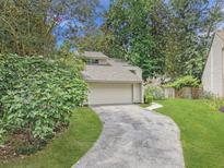 Charming home featuring a driveway leading to a two-car garage and lush surrounding greenery at 10 Stallion Ct, Charleston, SC 29407