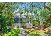 Charming two-story home with a screened porch and landscaped yard offers a welcoming curb appeal at 11 49Th Ave, Isle of Palms, SC 29451