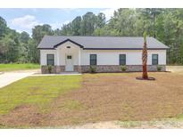 Charming single-story home features white siding, brick accents, and a freshly landscaped yard with a palm tree at 112 Southsong Ln, Goose Creek, SC 29445