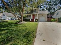 Charming two-story home with landscaped front yard, mature tree, and inviting red front door at 120 Apache Dr, Summerville, SC 29483